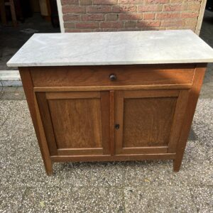 WhatsApp Image 2025-10-18 at 15.40.19 Kleine houten commode met wit marmeren blad – volledig naar wens af te werken Een prachtig kleinere commode met een echt wit marmeren blad — ideaal als commode in de babykamer, maar ook perfect voor in de hal of woonkamer als stijlvol opbergmeubel. Afmetingen: • Breedte marmeren blad: 95 cm • Diepte marmeren blad: 45 cm • Breedte commode: 87 cm • Werkhoogte wordt minimaal 90 cm — we plaatsen hiervoor eiken pootjes van in totaal 22,5 cm hoogte Deze commode krijgt dus nog mooie eiken pootjes (zoals al onze commodes), zodat hij qua hoogte perfect is voor gebruik. Het marmeren blad heeft een zachte, wit doorleefde uitstraling en vormt een prachtig contrast met de houten kast. De commode kan in originele houtkleur blijven of volledig in kleur naar wens worden afgewerkt — inclusief keuze in knopjes of handgrepen. Kleine houten commode met wit marmeren blad