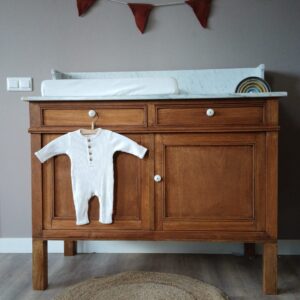 Breng warmte en karakter in de babykamer met deze prachtige vintage commode. Het meubel is uitgevoerd in massief hout met een rijke, warme tint en verfijnde details, waardoor het niet alleen praktisch is, maar ook een echte blikvanger. De commode biedt volop opbergruimte dankzij de ruime lades en het kastgedeelte, ideaal voor het netjes organiseren van kleertjes, verzorgingsproducten en accessoires. Het stevige blad is perfect geschikt als verschoonplek en combineert functionaliteit met stijl. De tijdloze uitstraling maakt dit meubel eenvoudig te combineren met zowel moderne als klassieke interieurs. Of je nu gaat voor een rustige, natuurlijke sfeer of een speelse babykamer, deze commode past zich moeiteloos aan. Een duurzaam en stijlvol meubel waar je jarenlang plezier van hebt – praktisch in gebruik en mooi om naar te kijken.